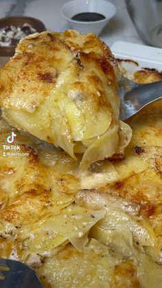 a close up of food on a plate with a fork and spoon in the foreground