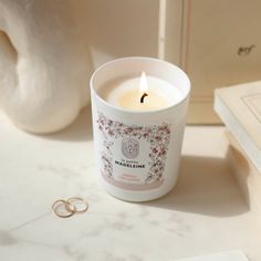 a candle sitting on top of a table next to a ring