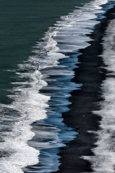 black and white photograph of waves in the ocean with reflections on the water, taken at low tide