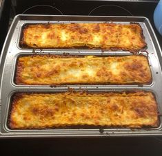 three pans filled with food sitting on top of an oven