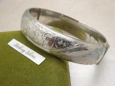 Hello and welcome to my shop. I am  offering to you this superb ladies silver vintage 1960's period hinged bangle / bracelet. As you will see in the pictures it is made in solid English Birmingham hallmarked 925 silver with a bright engraved floral design on side and plain on the other. the out. The bracelet has a push in lock which closes firmly and also has a safety chain..   The silver floral bracelet is in an excellent used vintage condition with only very slight age related surface wear as Six Photos, Floral Bracelet, Safety Chain, Silver Engraving, Hinged Bangle, Floral Vintage, Birmingham, Vintage Floral, Design Details