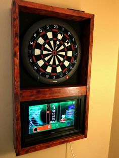 a dart board mounted to the side of a wall with an electronic darts game on it