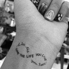 a person's wrist with some writing on it and a clock in the middle