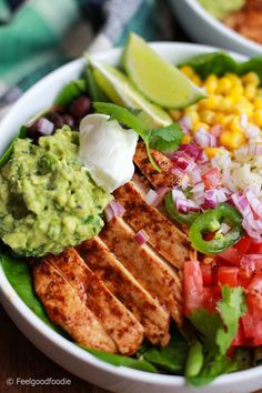 a bowl filled with meat, vegetables and guacamole