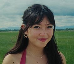 a woman in a red dress standing in a field