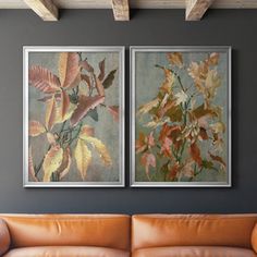 two paintings hanging on the wall above a couch in a living room with leather furniture