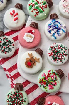 decorated christmas cookies are on a red and white towel