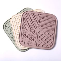 three coasters with designs on them sitting next to each other in front of a white background