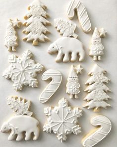 christmas cookies decorated with white icing and snowflakes on a sheet of paper