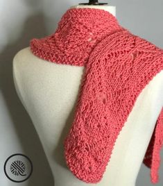 a close up of a mannequin wearing a pink knitted scarf on top of a white dummy