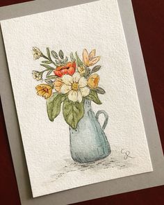 a watercolor painting of flowers in a blue vase on a white card with gray envelope