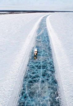 an aerial view of a boat traveling through the water covered in ice and snow,