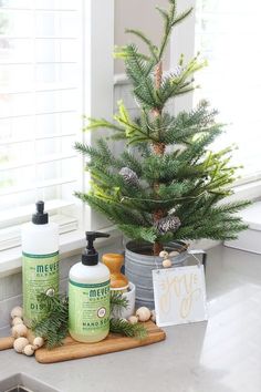 a small christmas tree sitting on top of a counter next to two bottles of lotion