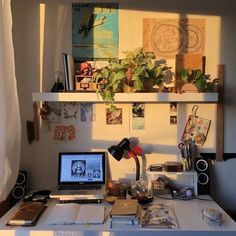 a laptop computer sitting on top of a desk next to a window covered in curtains