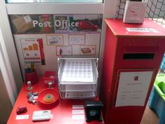 a red desk with a post office machine on it's side and other items around it