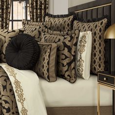 a bed with black and gold pillows on it