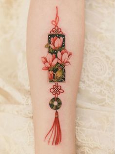 a woman's arm with flowers and tassels on the side of her body