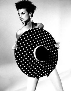 a woman is holding a large polka dot object