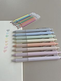 a bunch of pens sitting on top of a white paper next to some markers and pencils