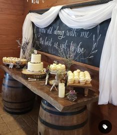 a table topped with cupcakes next to a chalkboard