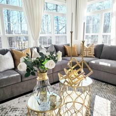 a living room filled with lots of furniture and flowers on top of a coffee table