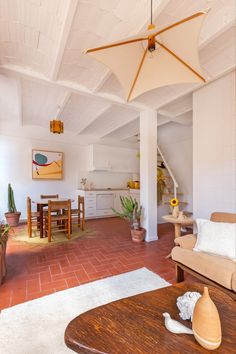 a living room filled with furniture and a wooden table next to a white ceiling fan