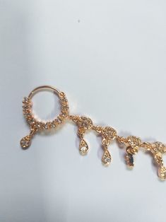 a close up of a pair of gold colored metal ear rings with dangling charms on them