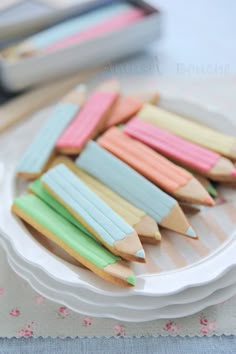 several colored pencils are on a white plate