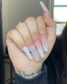 a person holding up their hand with white and pink nails