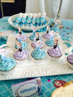 there are cupcakes with blue frosting on the tray and some other decorations