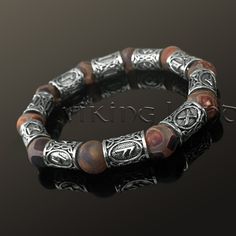 a bracelet made out of silver and wood beads with an intricate design on the clasp