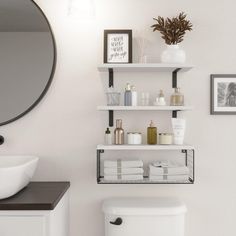 a white toilet sitting under a bathroom mirror next to a shelf filled with bottles and soaps