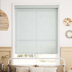 a living room scene with focus on the blinds in the window and the bed frame