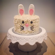 a cake decorated with white frosting and pink ears