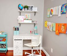 a child's desk and chair in the corner of a room with gray walls