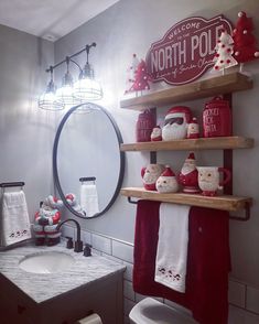 the bathroom is decorated for christmas with red and white accessories on shelves above the sink