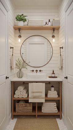 a bathroom with a sink, mirror and towels on the shelf in front of it