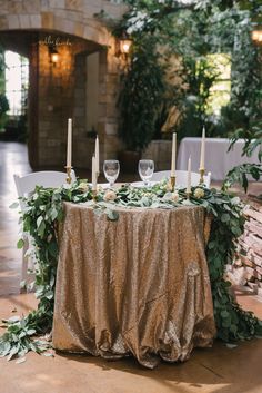 the table is set with candles and greenery for an elegant wedding reception at stone house