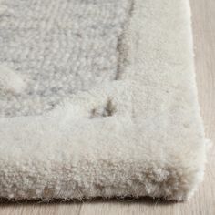 a close up view of a rug on the floor with white fur and wood floors