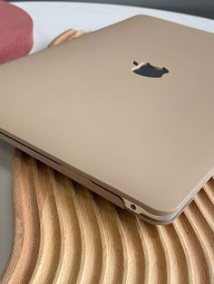 an apple laptop sitting on top of a wooden table