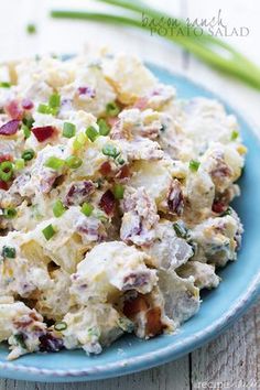 a blue plate filled with potato salad on top of a wooden table