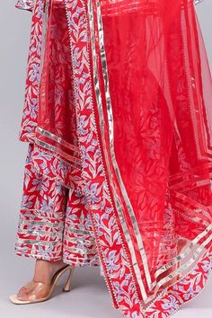 Red sleeveless printed anarkali with metallic stripes and sweetheart neckline. Paired with sharara and printed hem dupatta.
Component: 3
Pattern: Printed
Type Of Work: Floral
Neckline: Sweetheart
Sleeve Type: Sleeveless
Fabric: Anarkali and Sharara: Cotton, Dupatta: Soft Net
Color: Red
Other Details: 
Printed hem dupatta
Metalic stripes
Occasion: Wedding - Aza Fashions Red Sets With Gota Work For Festivals, Red Zari Work Palazzo Set For Festivals, Red Palazzo Set With Mirror Work For Festivals, Anarkali Red Sharara For Festivals, Red Palazzo Set With Dupatta For Festivals, Red Sharara With Mirror Work For Festivals, Red Anarkali Sharara For Festivals, Multicolor Anarkali Sleeveless Sharara, Red Straight Kurta Sharara For Festivals