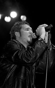 a man singing into a microphone on stage