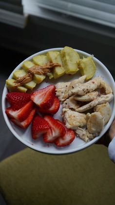 a white plate topped with sliced fruit and chicken