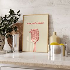 a kitchen counter with a framed poster on the wall next to some vases and lemons