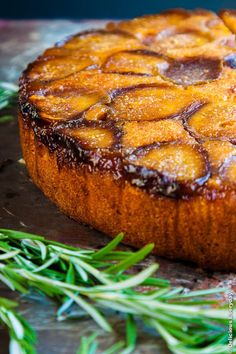 a pineapple upside down cake with rosemary sprigs on the side, ready to be eaten