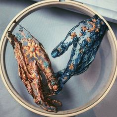 two hands that are made out of fabric in a circular frame on a blue background