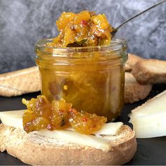 a sandwich with pickles and cheese on it next to a jar of pickles