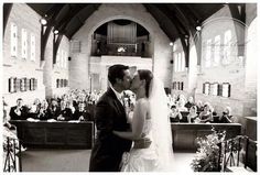 a bride and groom kissing in front of an audience