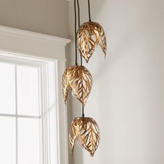 three lights hanging from the ceiling in a room with white walls and window sill